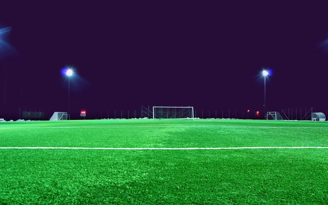Soccer field illuminated by sports lighting at night