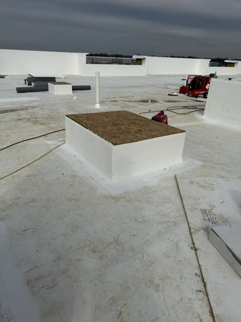 A white commercial rooftop area with an hvac curb base and portable powered construction equipment